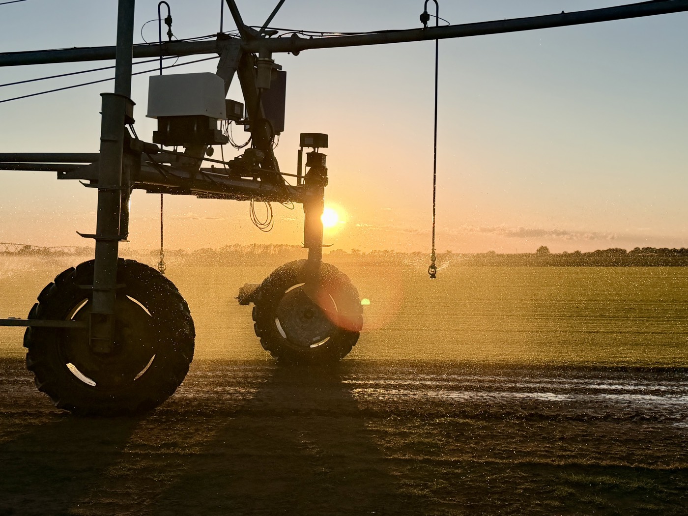 Center pivot tower backlit by the setting sun